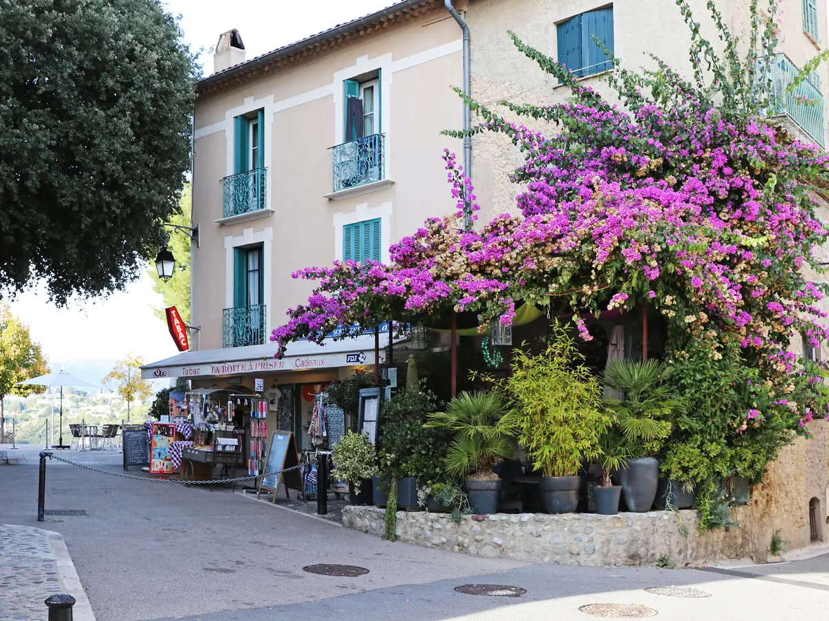 Une ruelle fleurie du village du Haut-de-Cagnes, bougainvilliers et terrasse