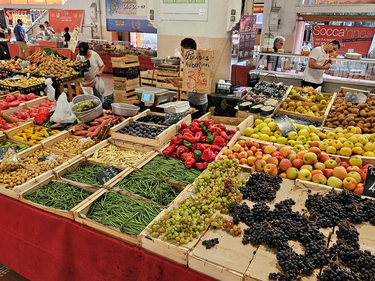 Étals de fruits et légumes sous la halle du marché Forville à Cannes