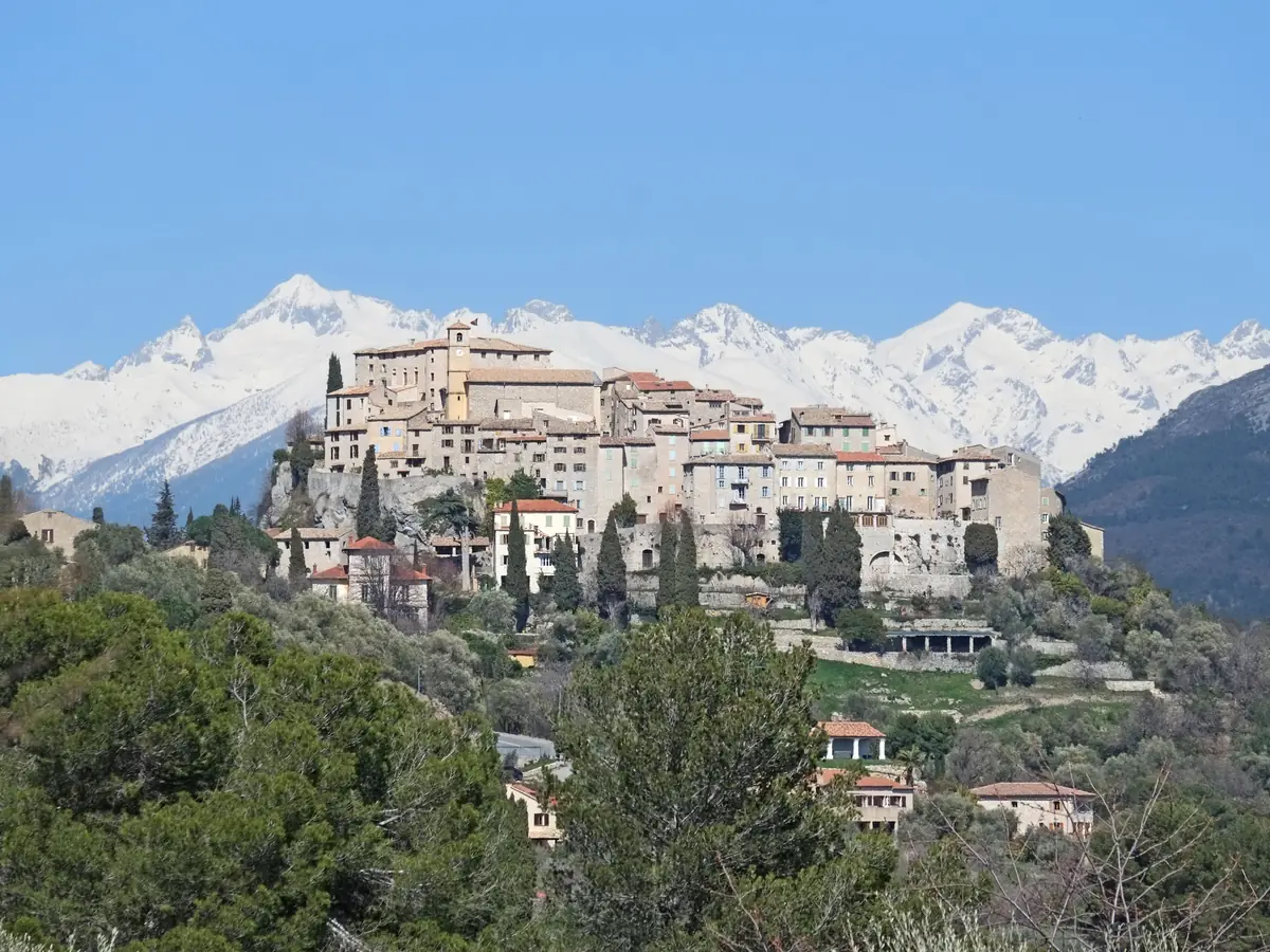 Le village de Carros avec les montagnes enneigées du Mercantour en arrière-plan