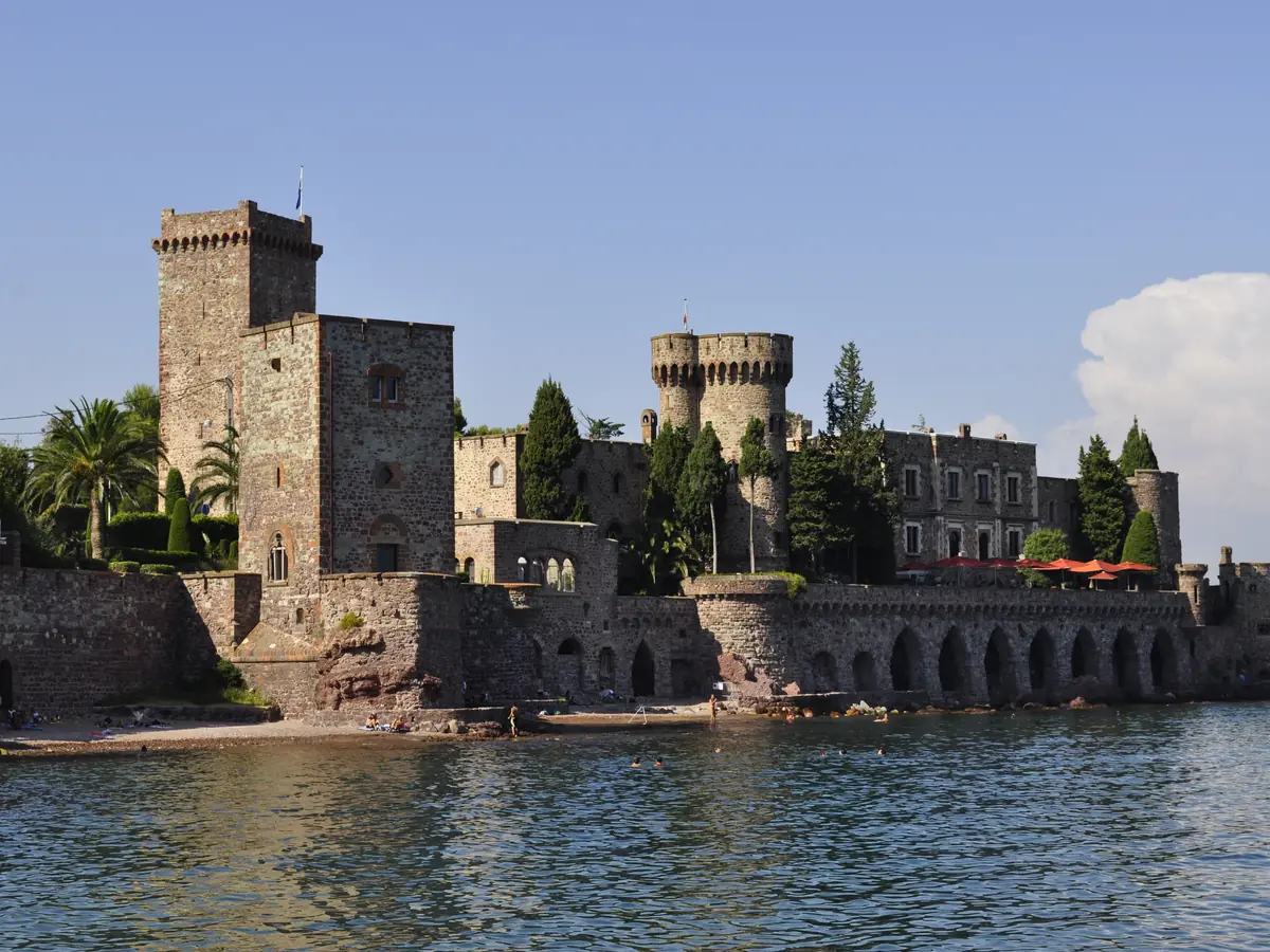 Le château de la Napoule et ses tours crénelées au bord de la mer, vu depuis la plage