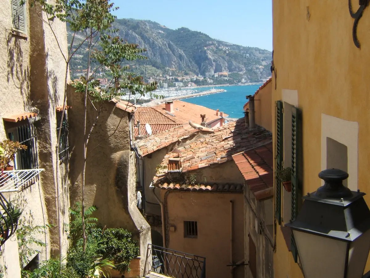 Ruelle en escalier de la vieille ville de Menton avec vue sur la mer