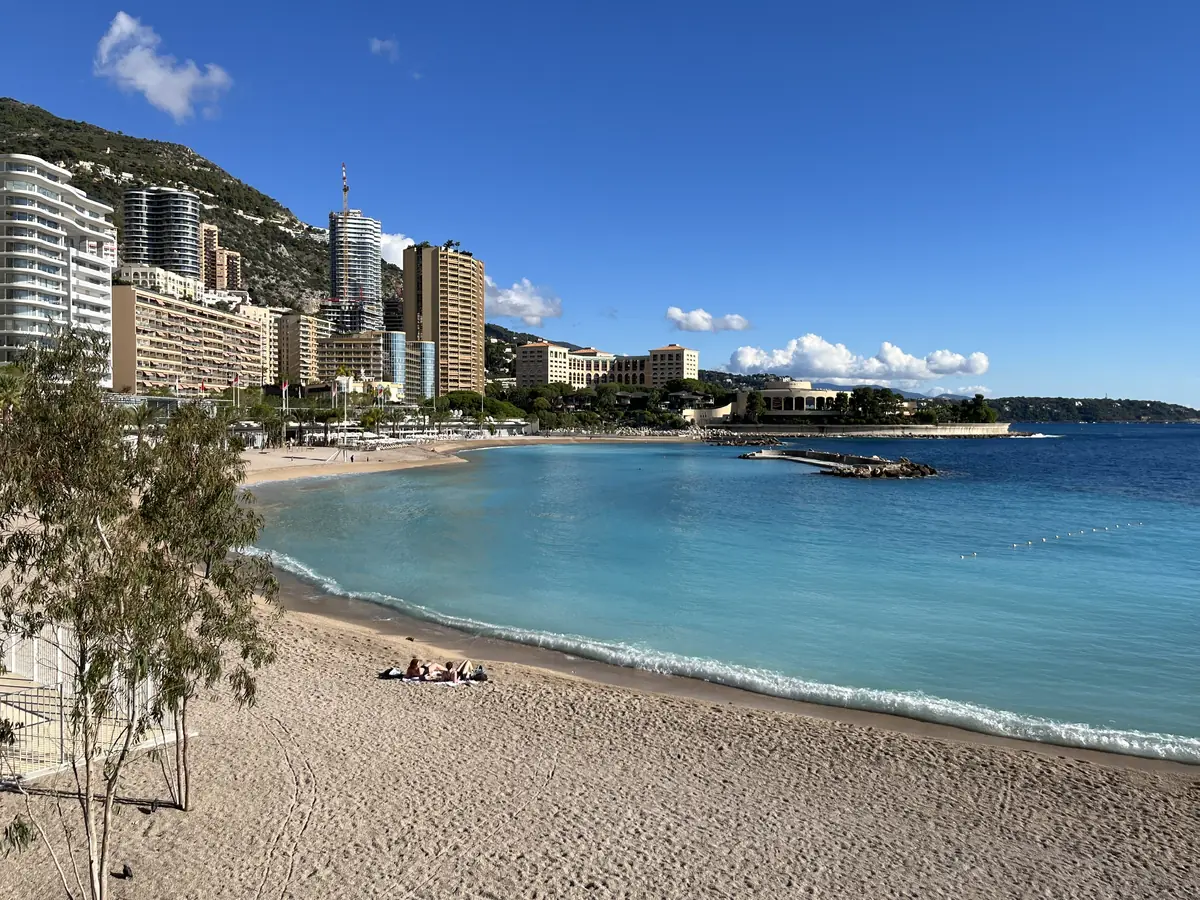 La plage du Larvotto à Monaco, sable clair, eau turquoise et immeubles de Monte-Carlo